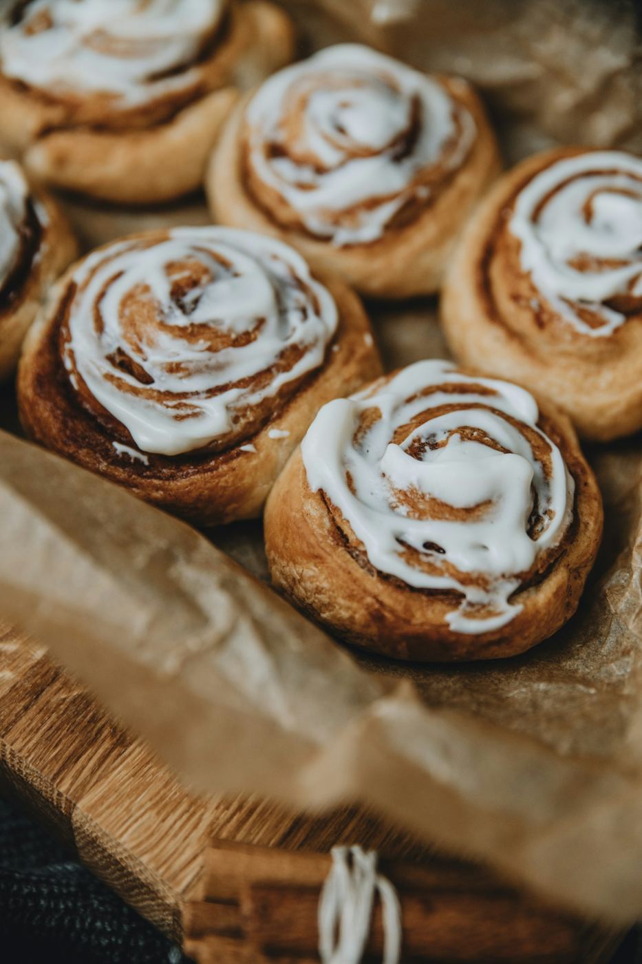 Kanelboller med hvit glasur på bakepapir