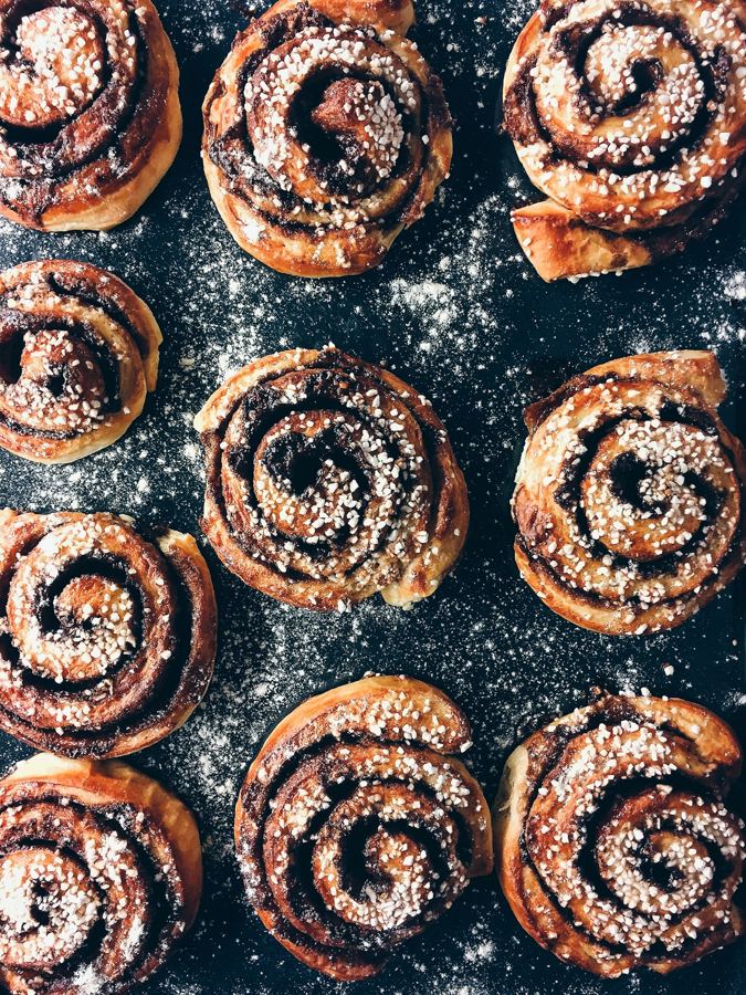 Kanelboller sett ovenfra på mørk, melet benk